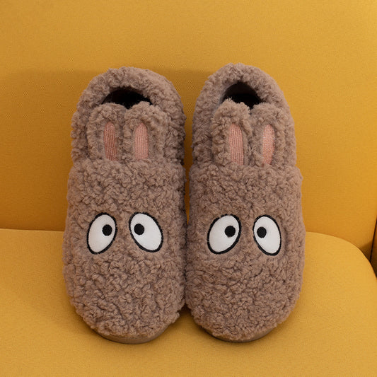 Pair of brown slippers with cartoonish eyes on a yellow background