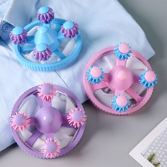 Three colorful fan-shaped toys on a light gray surface with a white fabric background.