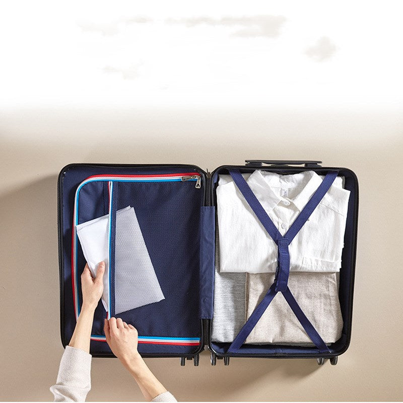 Person packing a suitcase with clothes and a folder, on a neutral background