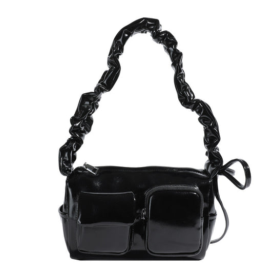 Black handbag with a textured handle on a white background