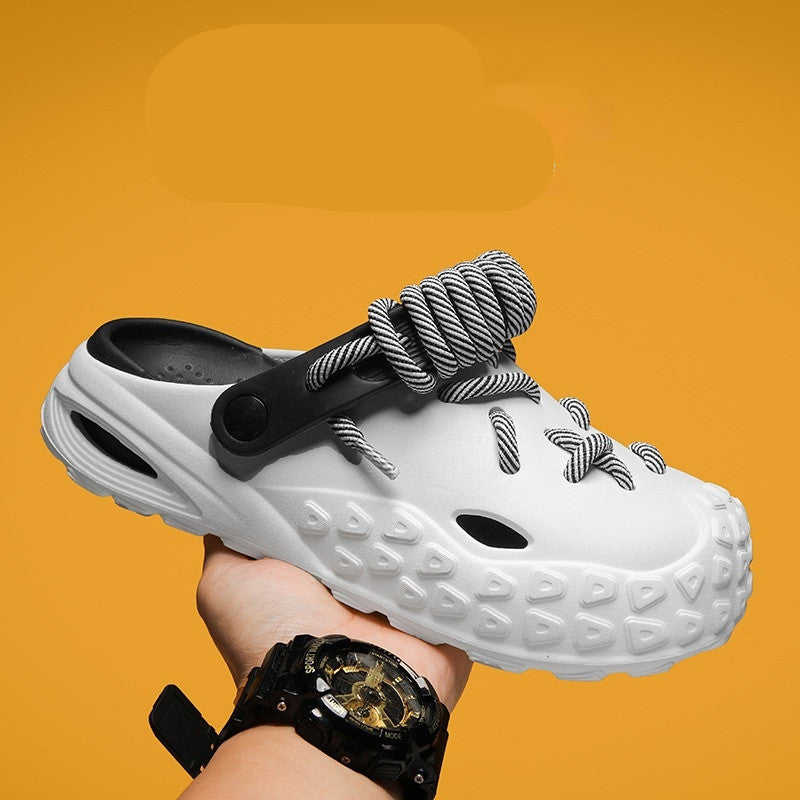 White sandal with thick sole held by a hand against an orange background