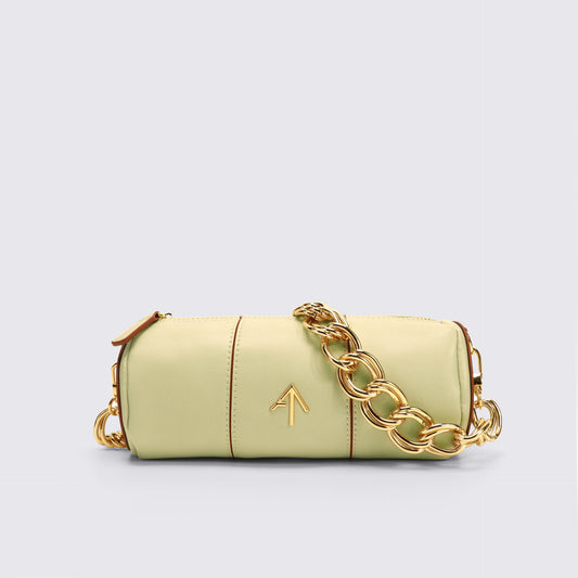 Light green handbag with gold chain detail on a light gray background