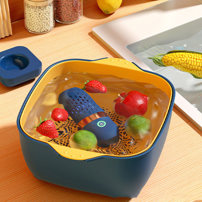 Blue and yellow container with fruits and a small blue device on a wooden surface