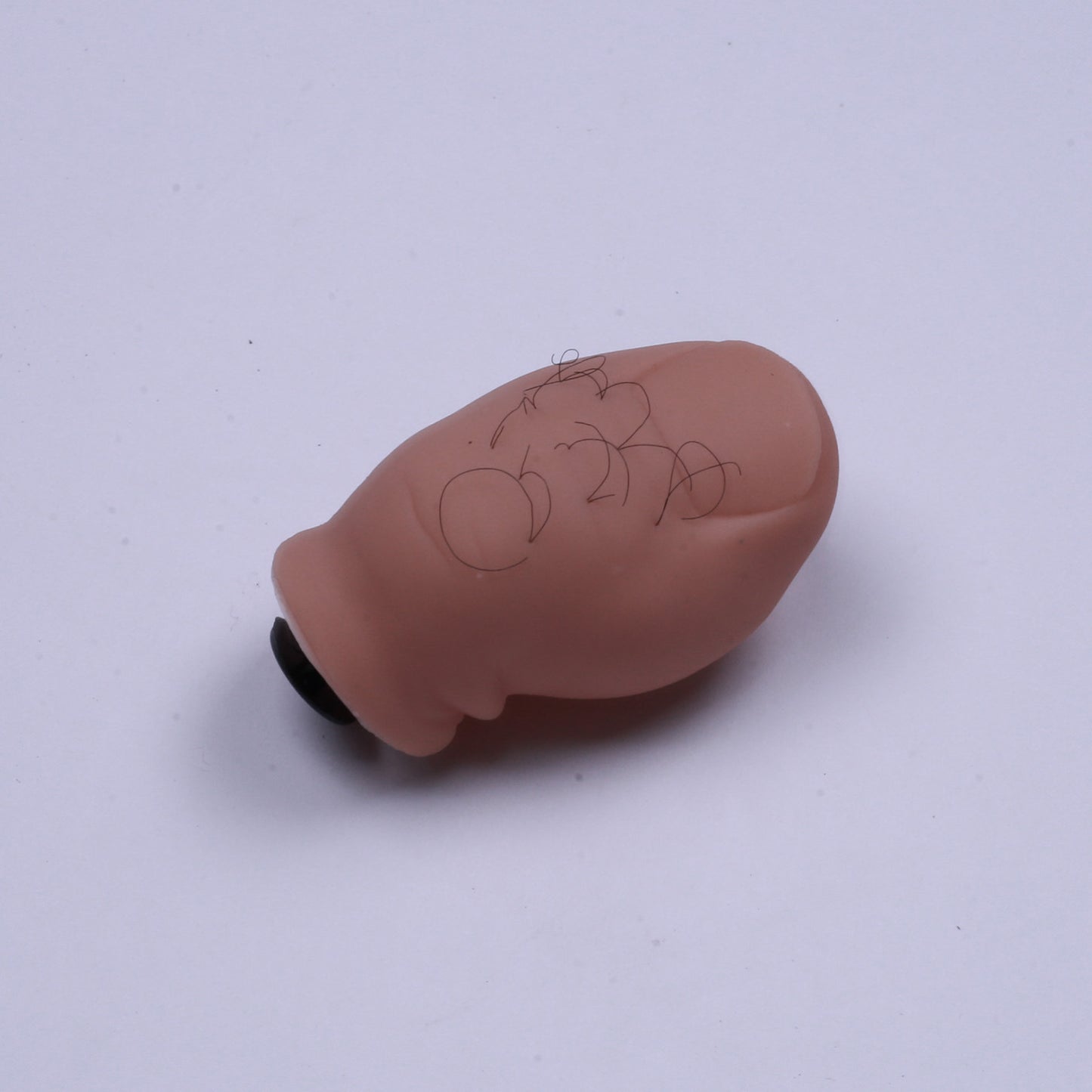 Small brown object with writing on a white background