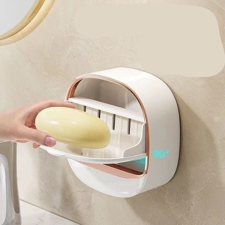 Wall-mounted soap holder with a hand placing a bar of soap inside, on a beige wall.