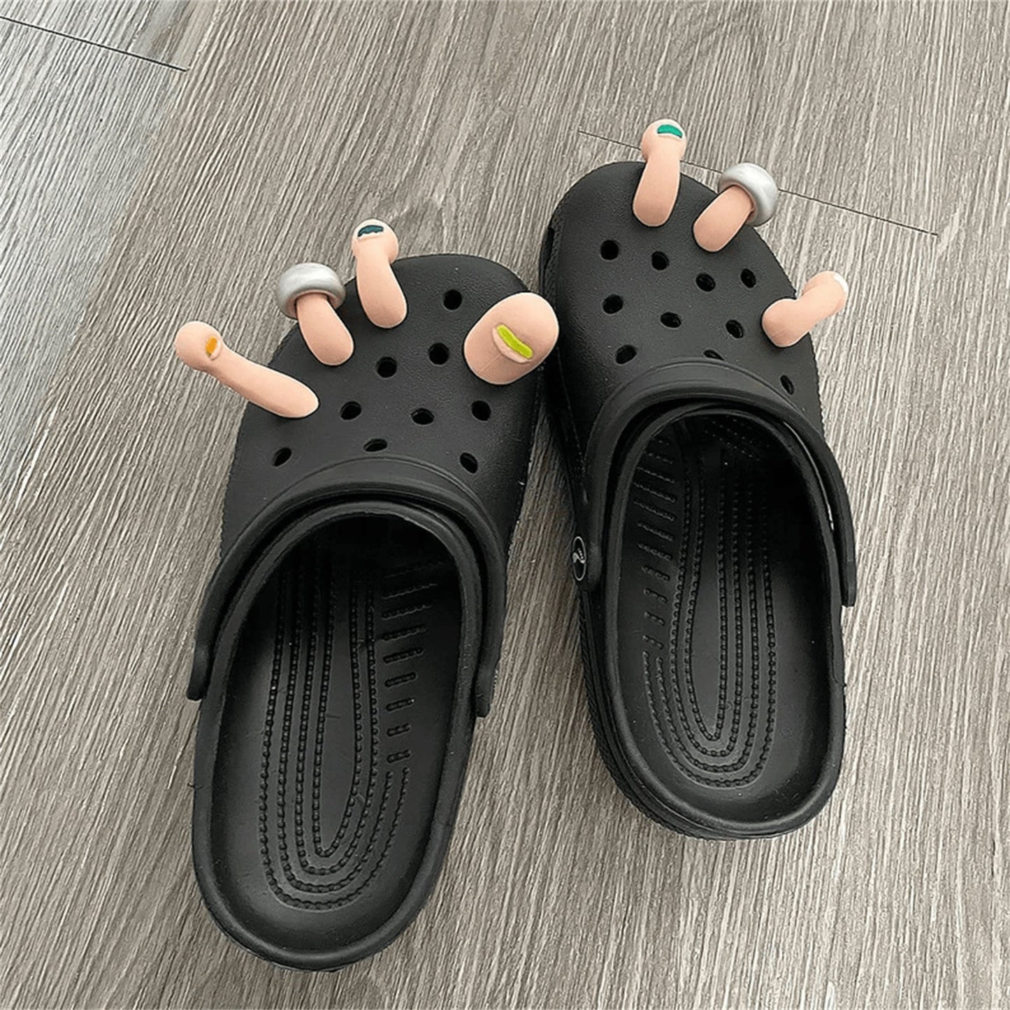Black slippers with cartoonish toes on a wooden floor