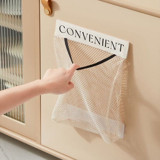 Hand reaching for a mesh bag labeled 'CONVENIENT' attached to a cabinet.