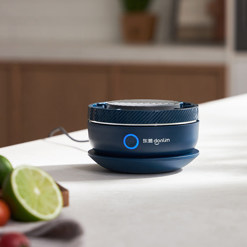 Blue food dehydrator on a kitchen counter with fruits in the background