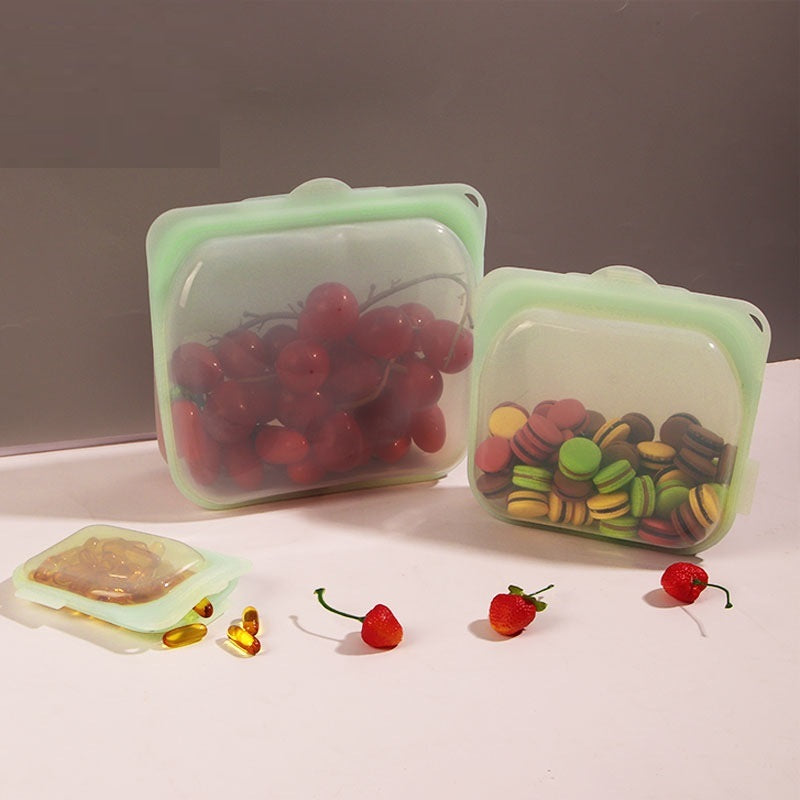 Silicone food containers with fruits and candies on a neutral background