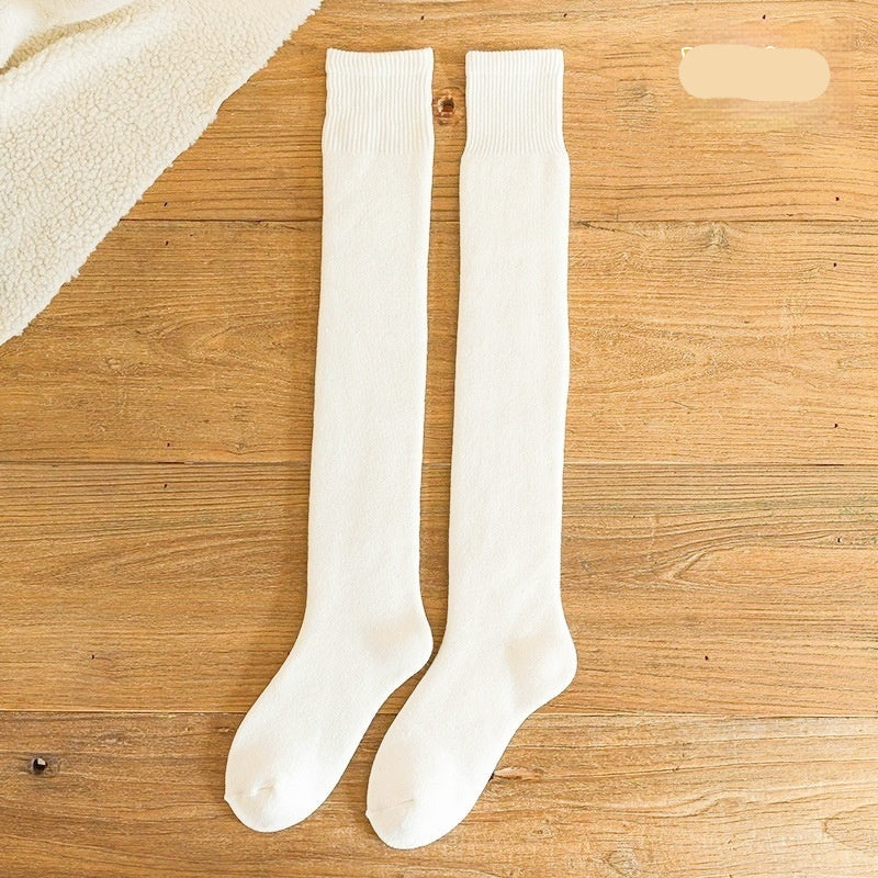 White knee-high socks on a wooden surface with 'White' text.