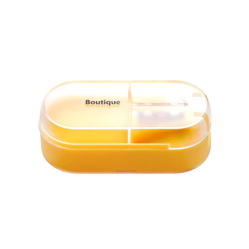 Yellow pill box with clear lid on a white background, branded 'Boutique'.
