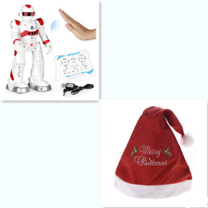 White robot toy with red accents and a USB cable, next to a red Christmas hat with 'Merry Christmas' text.