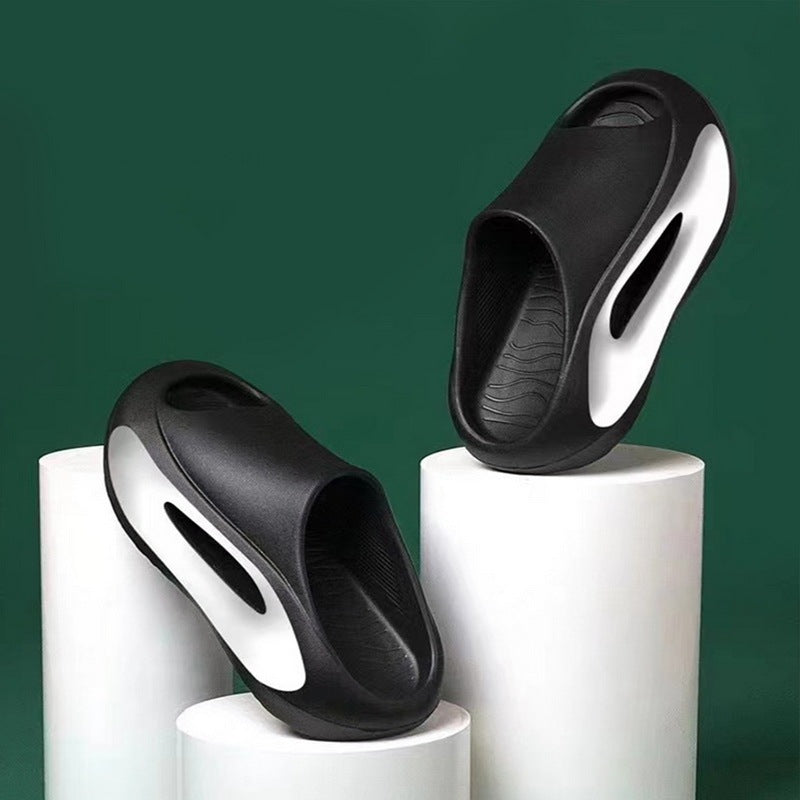 Black and white slippers on cylindrical white stands against a green background
