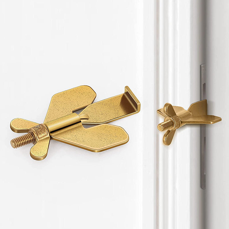 Gold door stopper attached to a white door