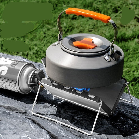 Camping stove with orange handle on a rock with grass background