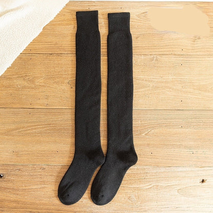 Black knee-high socks on a wooden surface with 'Black' text above.