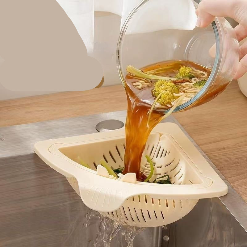 Magnetic draining filter basket being used to drain noodles from a glass bowl over a sink.