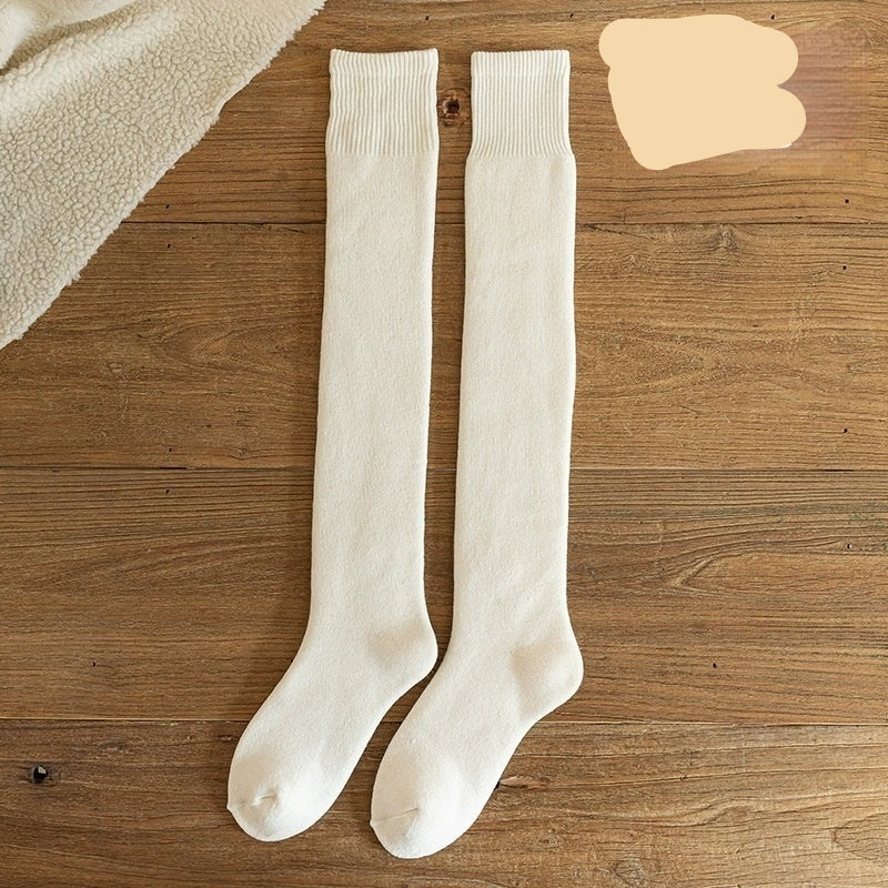 Pair of white knee-high socks on a wooden surface with 'Milky White' text.