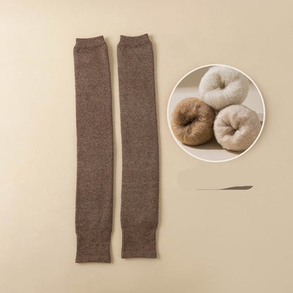 Dark brown leg warmers on a beige background with yarn balls in the corner.