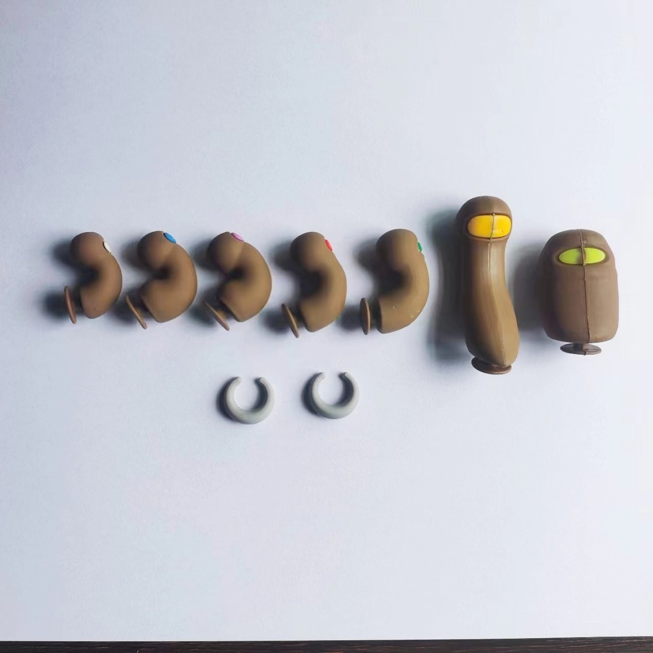 Set of brown earbud components on a white background