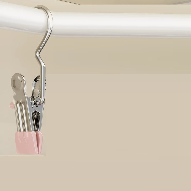 Metallic clip with pink holder on a beige background