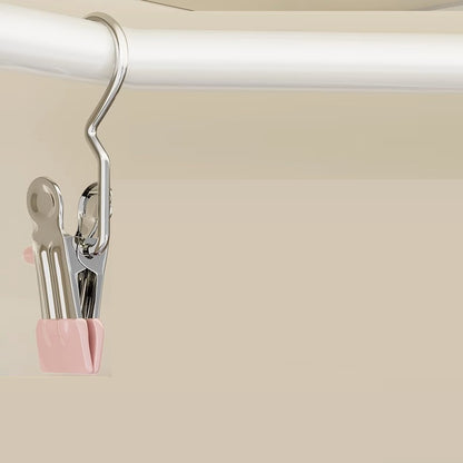 Metallic clip with pink holder on a beige background