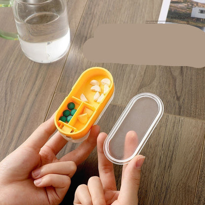 Hand holding a compartment pill box with pills on a wooden surface