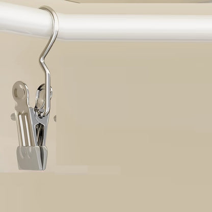 Metal hanger clip on a white rod against a beige background