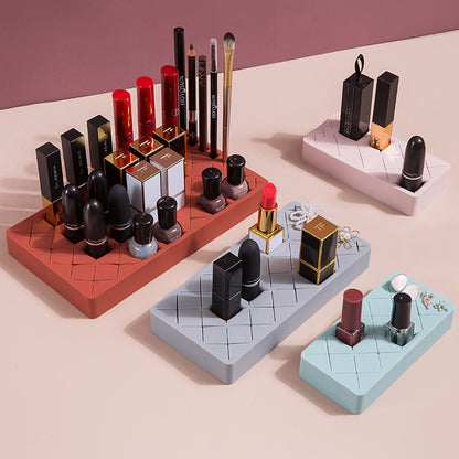 Makeup items including lipsticks, nail polishes, and brushes on geometrically designed stands.