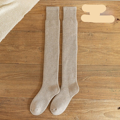 Pair of light beige knee-high socks on a wooden surface with 'Light coffee' text.