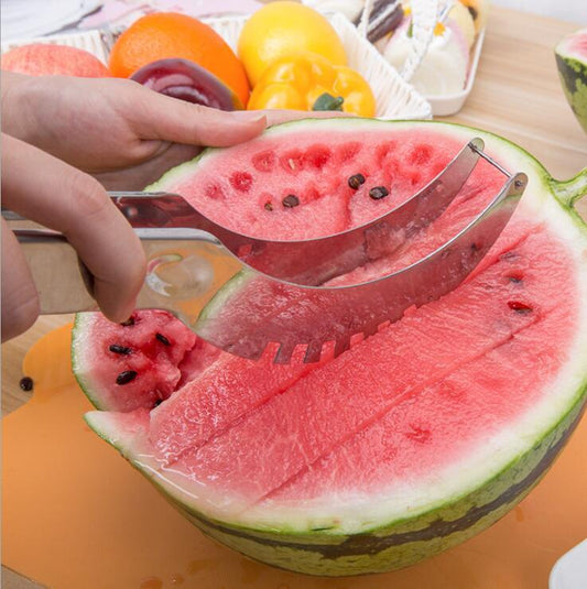Watermelon slicer cutting into a watermelon with a hand holding it, on a wooden surface.