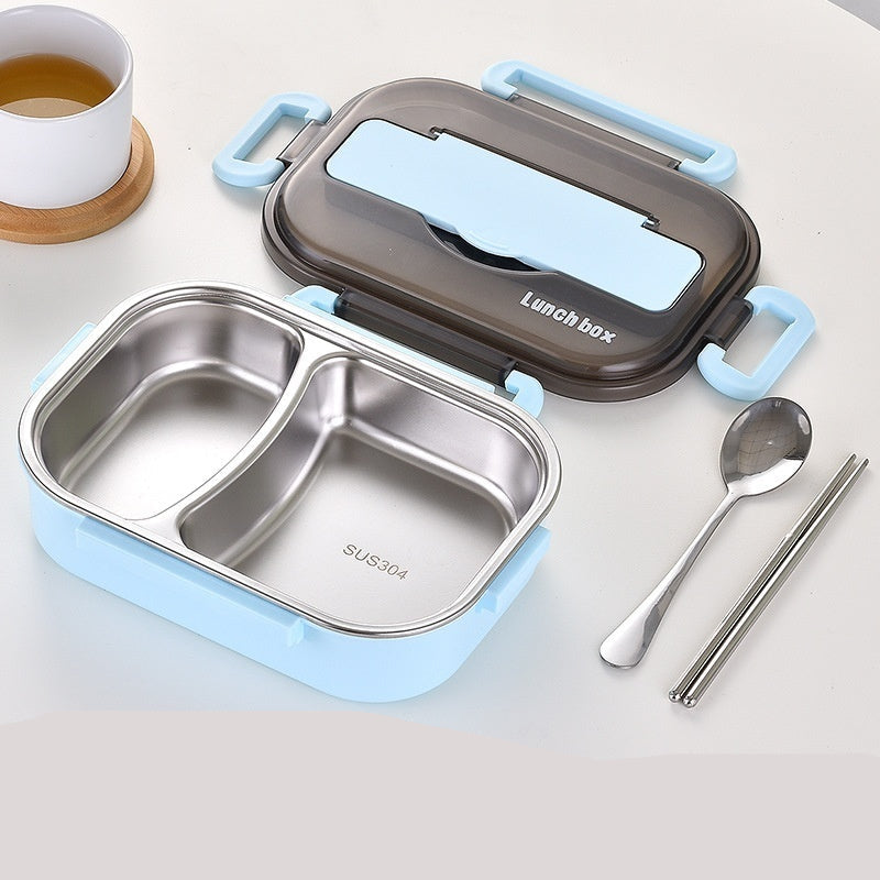 Stainless steel lunch box with compartments, spoon, and chopsticks on a white surface.