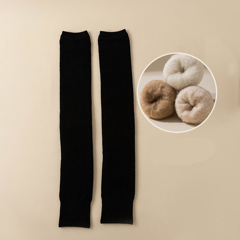 Black leg warmers on a beige background with a close-up of yarn balls in the corner.