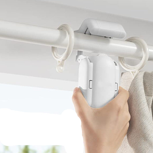 Hand holding a white curtain rod holder against a neutral background